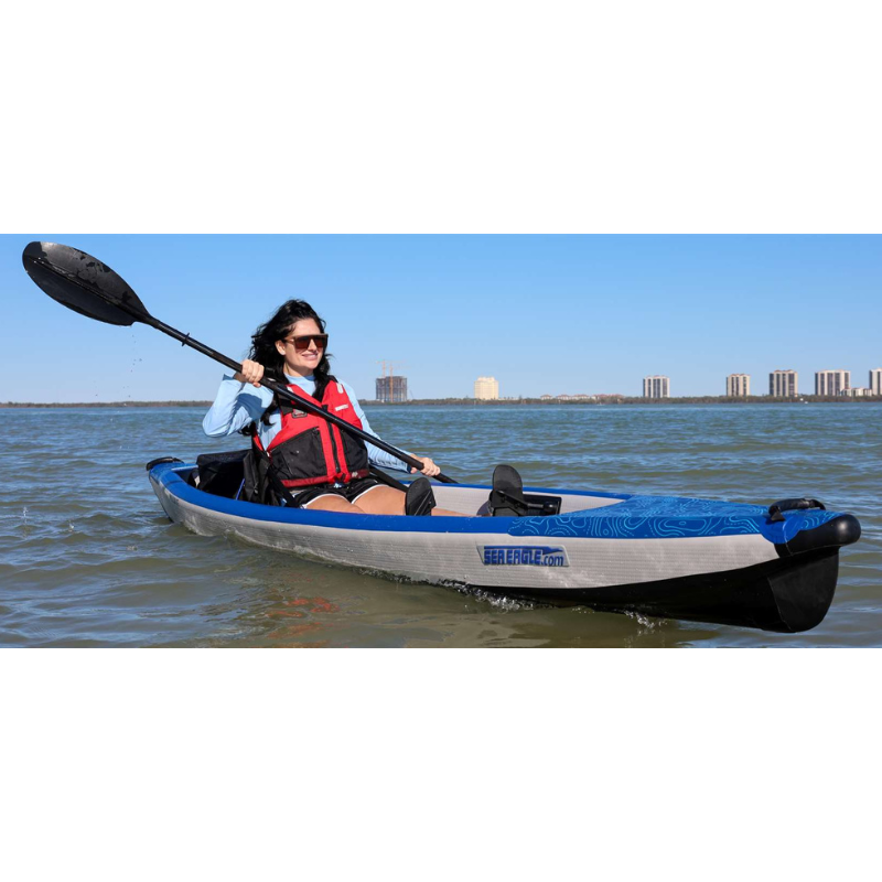 Sea Eagle RazorLite 393RL Inflatable Kayak Person kayaking on a body of water with a city skyline in the background