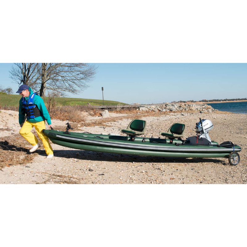 Sea Eagle FSK16 FishSkiff Inflatable Fishing Boat Person pushing a green inflatable boat on a beach with a clear sky.