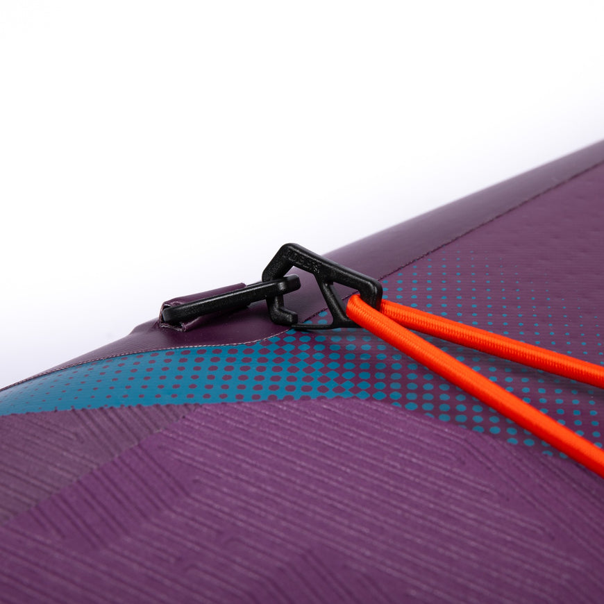 Close-up of a purple and blue textured surface with an orange strap and black clip.